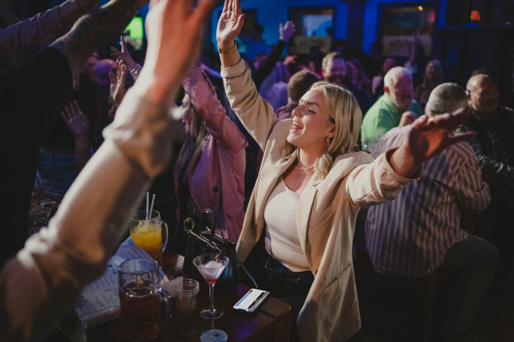 women singing with hands up